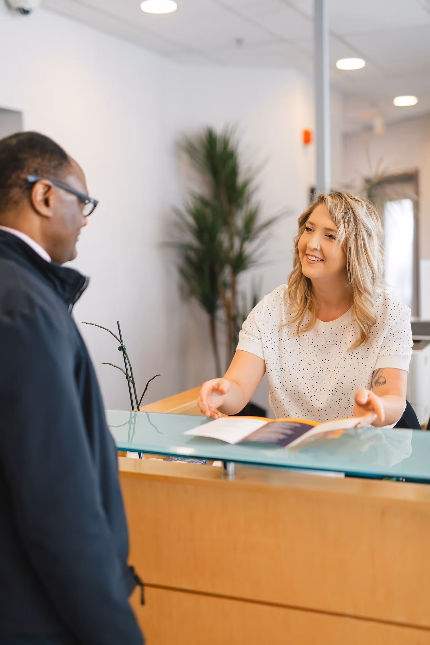 Smiling Pathways employee speaking with Pathways client at front desk