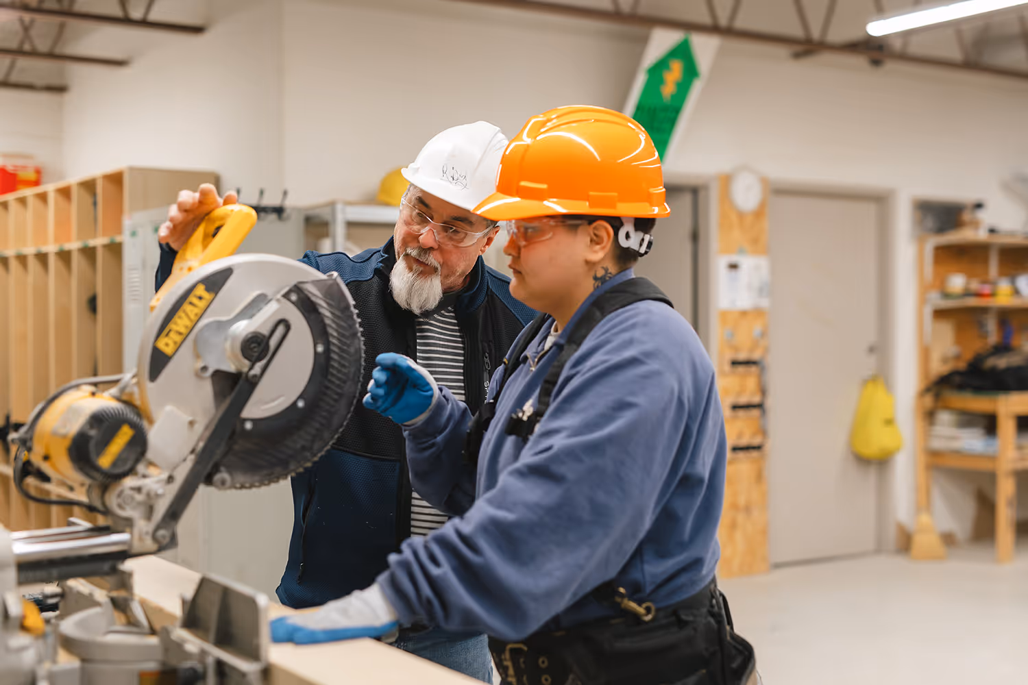 Pathways instructor demonstrating how to use a table saw while student observes