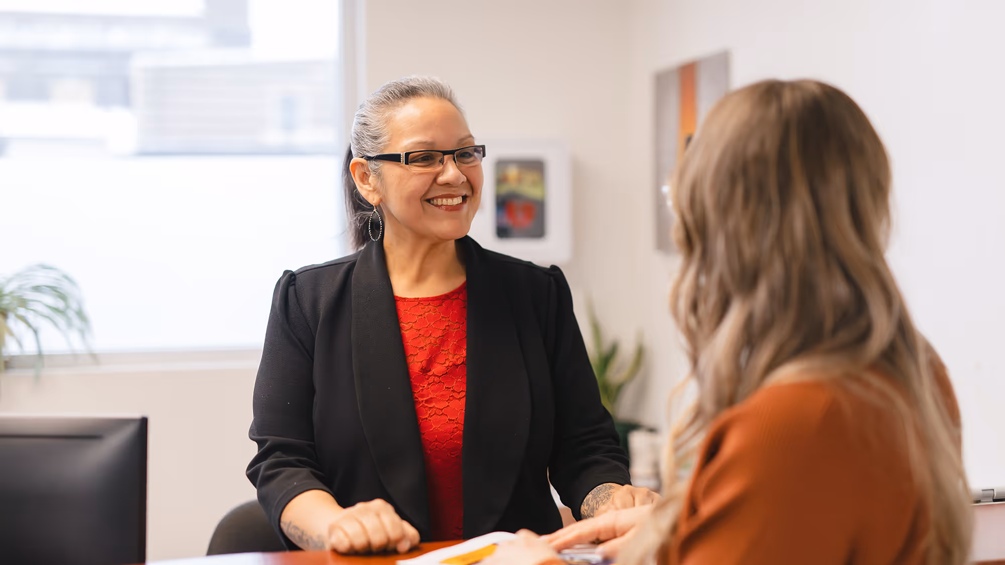 Two women standing together and smiling while in conversation