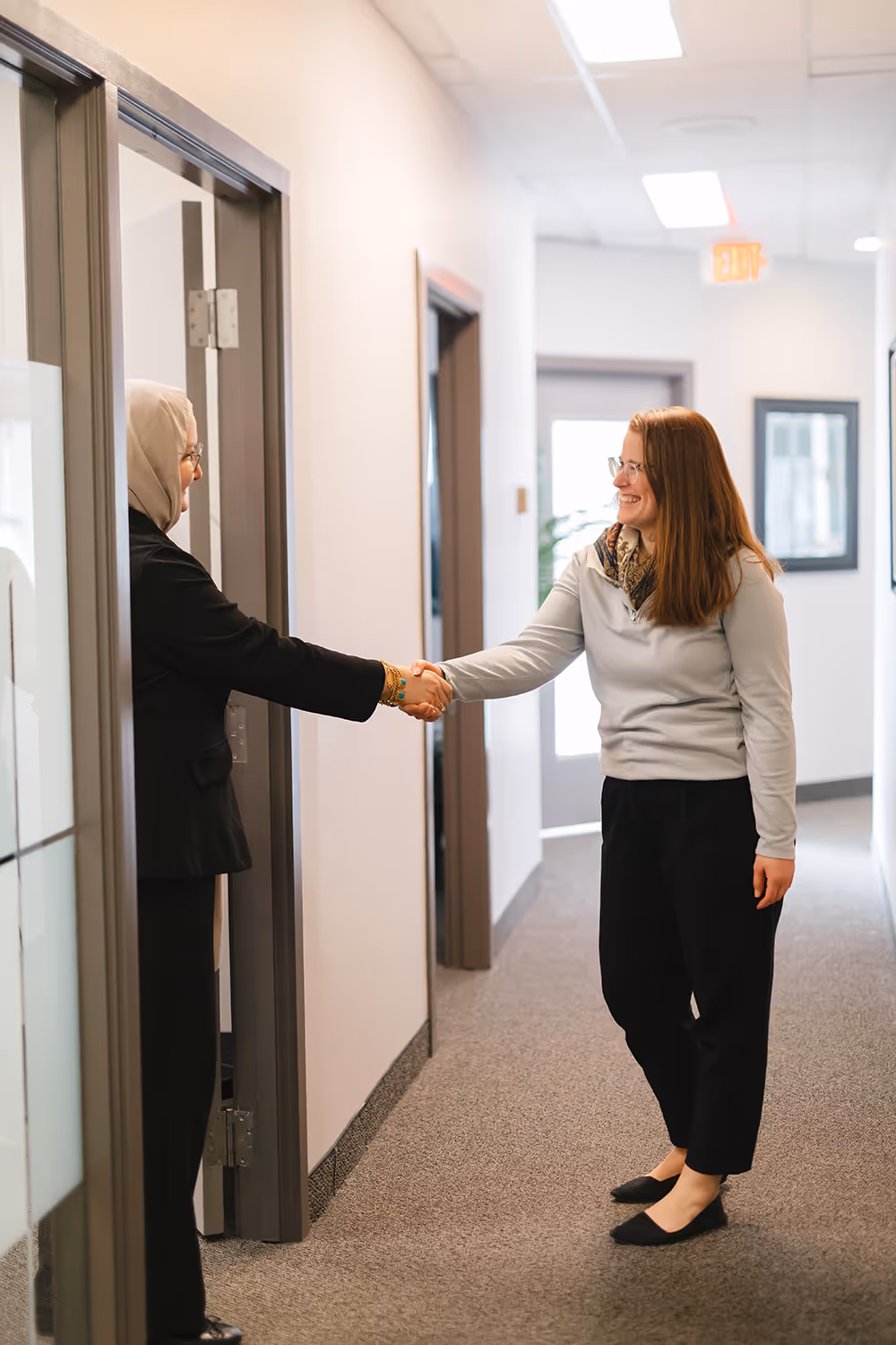 Employer smiling and shaking hands with potential employee
