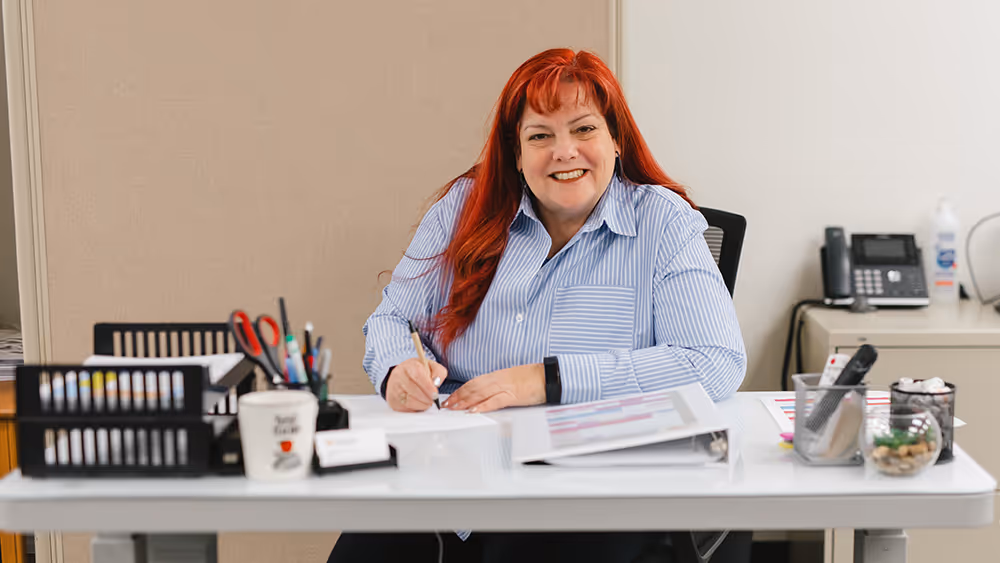 Smiling Pathways instructor sitting at desk 