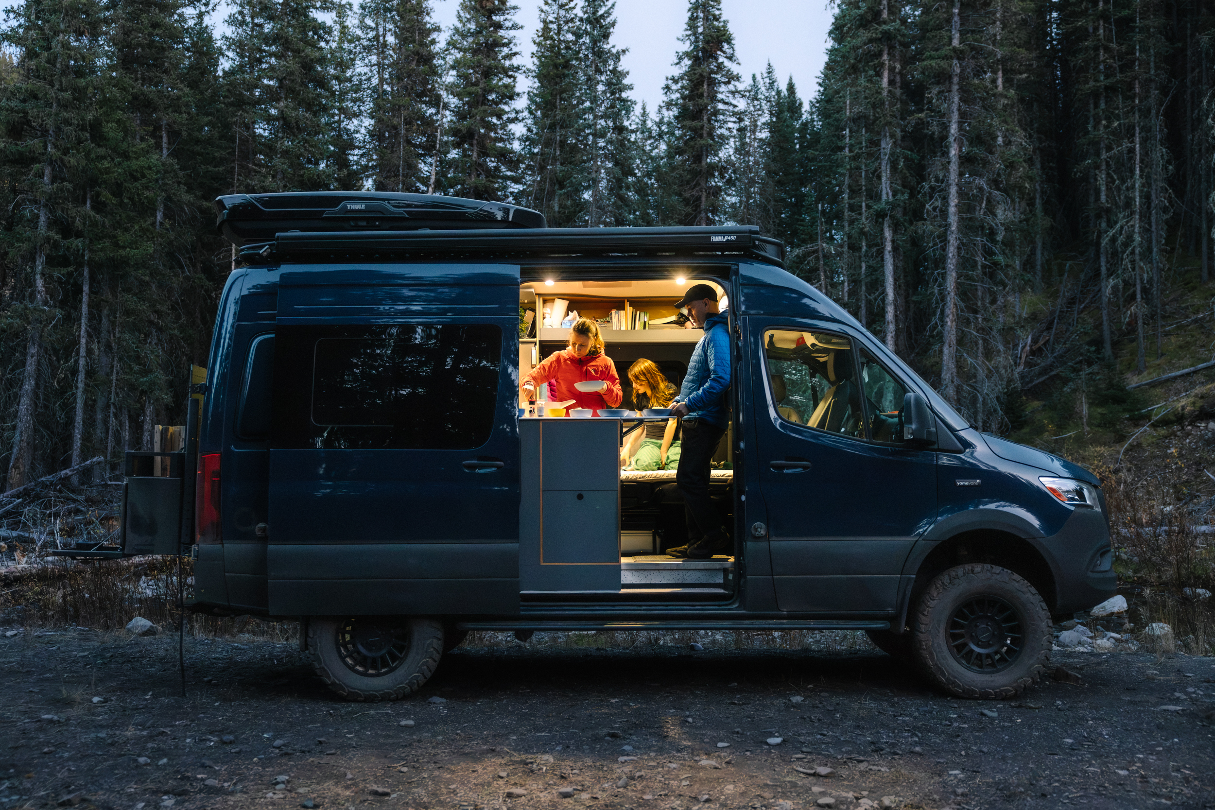 The Cox family prepares dinner inside the van.=
