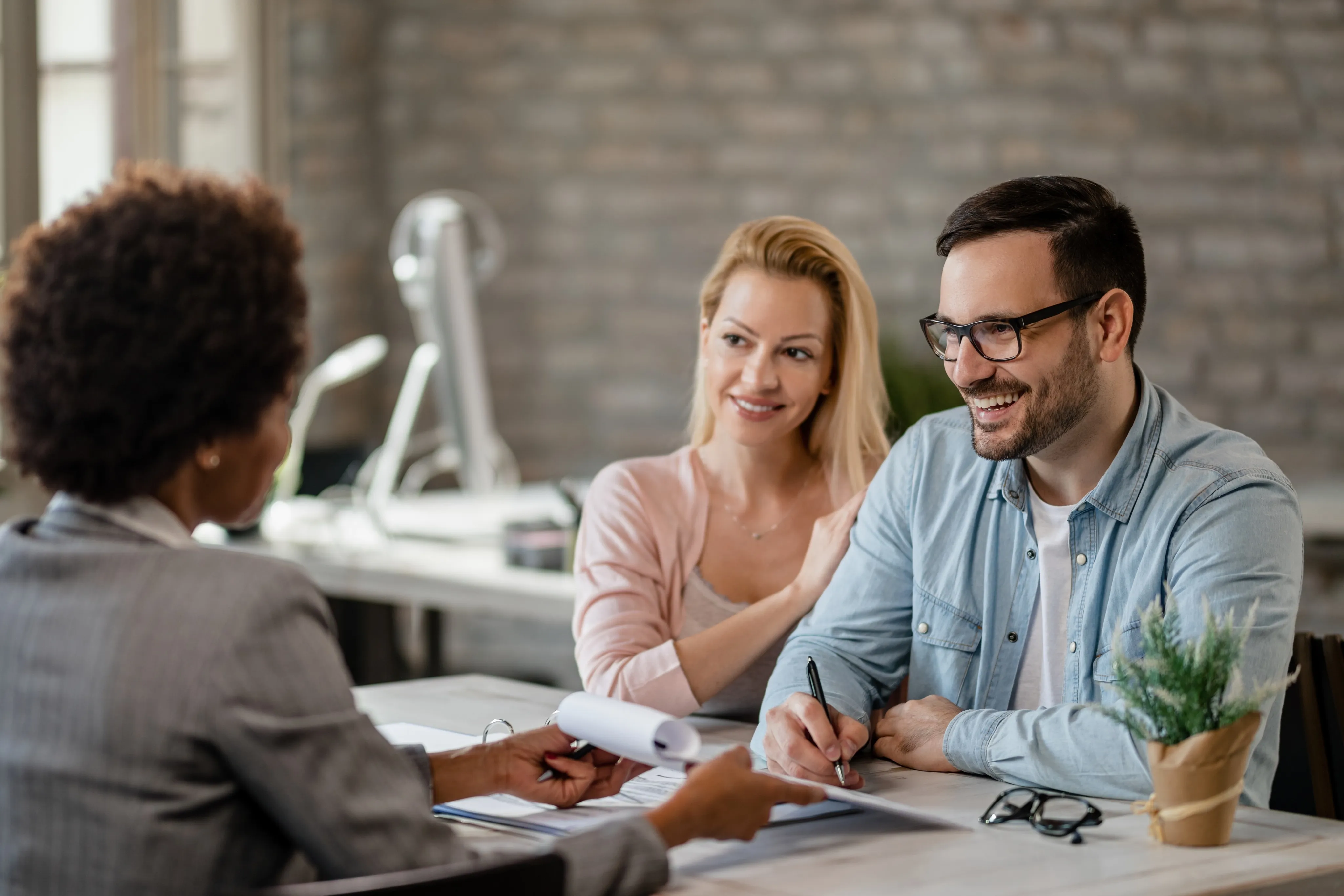 Professional couple meeting with advisor, discussing policies at an independent insurance agency in South Florida.