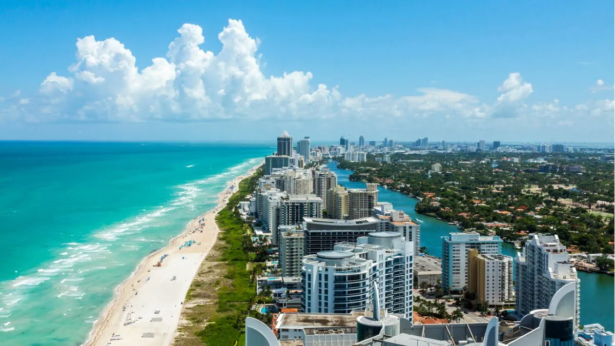 A South Floridai skyline and oceanfront are seen from above, protected by an independent insurance.