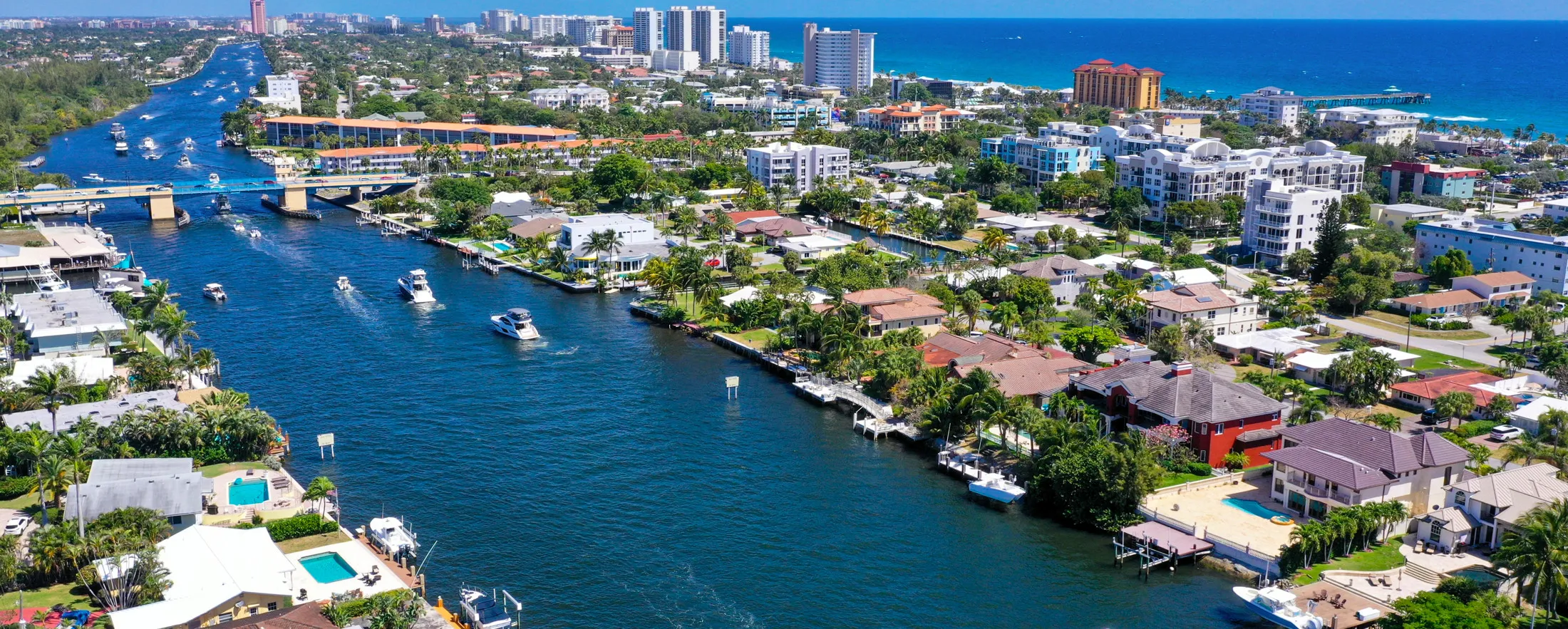 An aerial view of boats cruising along the scenic waterway of Deerfield Beach.