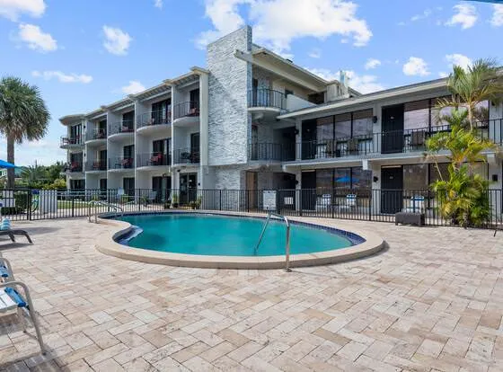 A modern commercial property with a sunny pool area in Deerfield Beach, safeguarded by an independent insurance agency in South Florida.