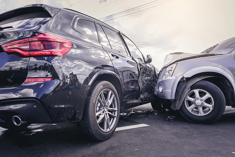 Two SUVs with severe collision damage are stopped on the road after an accident, emphasizing the importance of having accident coverage through an independent insurance agency in South Florida.