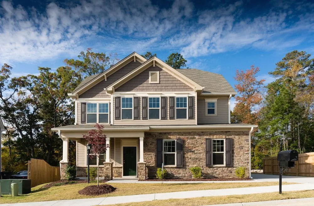A modern house stands tall with a well-maintained front yard under a bright blue sky, representing the security and peace of mind offered by an independent insurance agency in South Florida before disaster strikes.