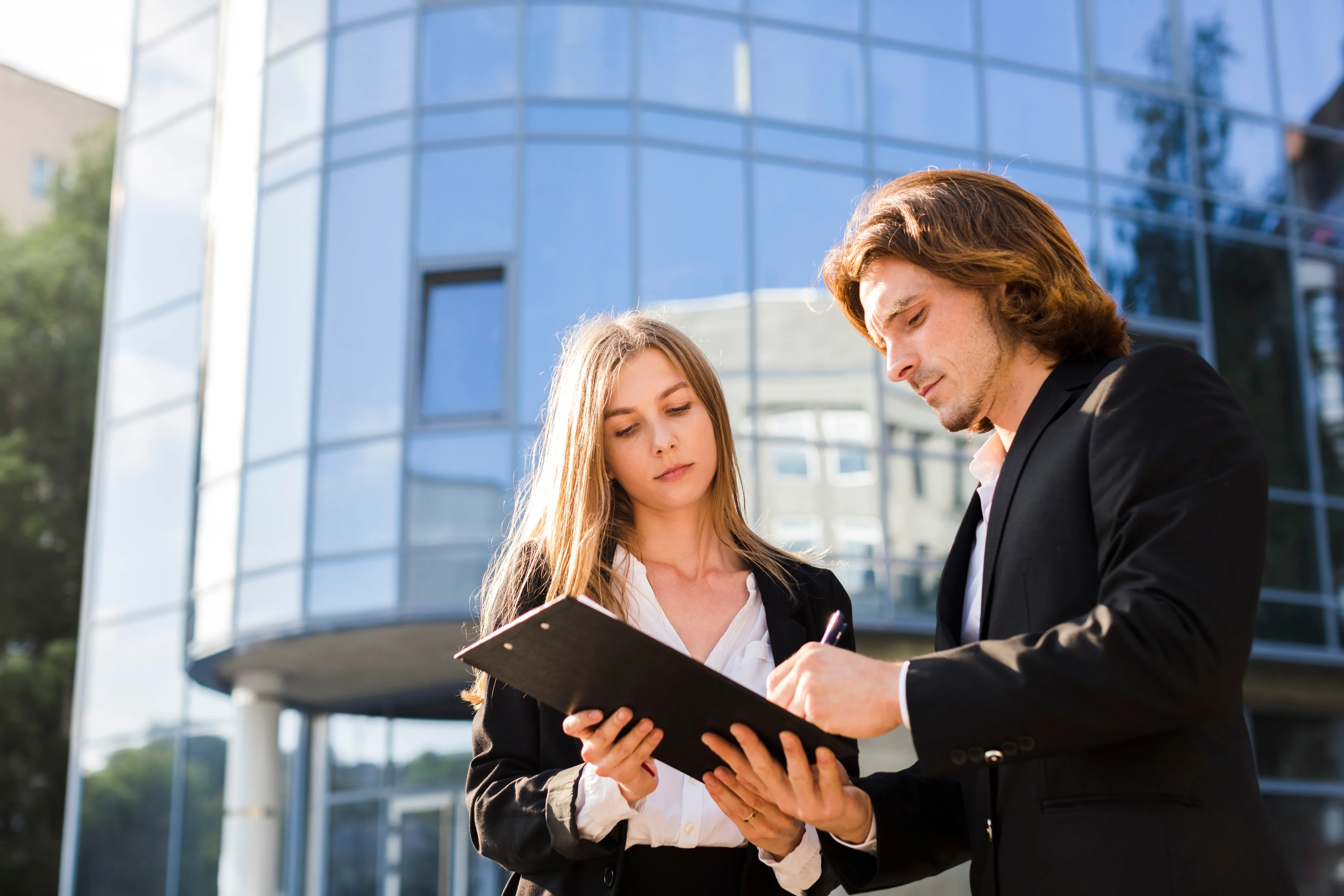 Two businesspeople review documents on commercial auto insurance in South Florida.