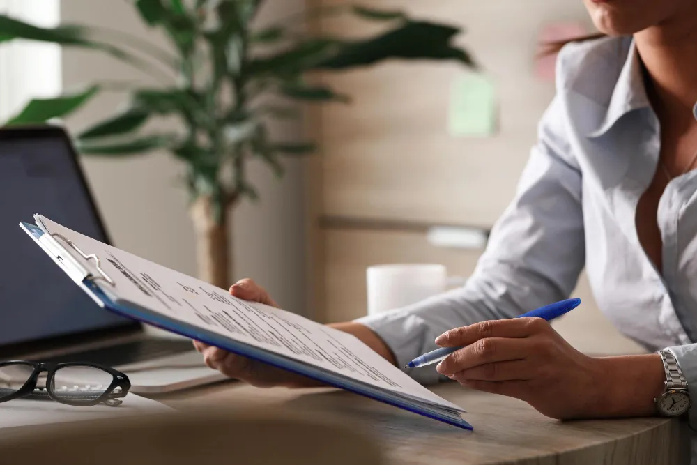 A professional woman reviews insurance documents at her desk, helping clients find the best coverage in Coral Springs.