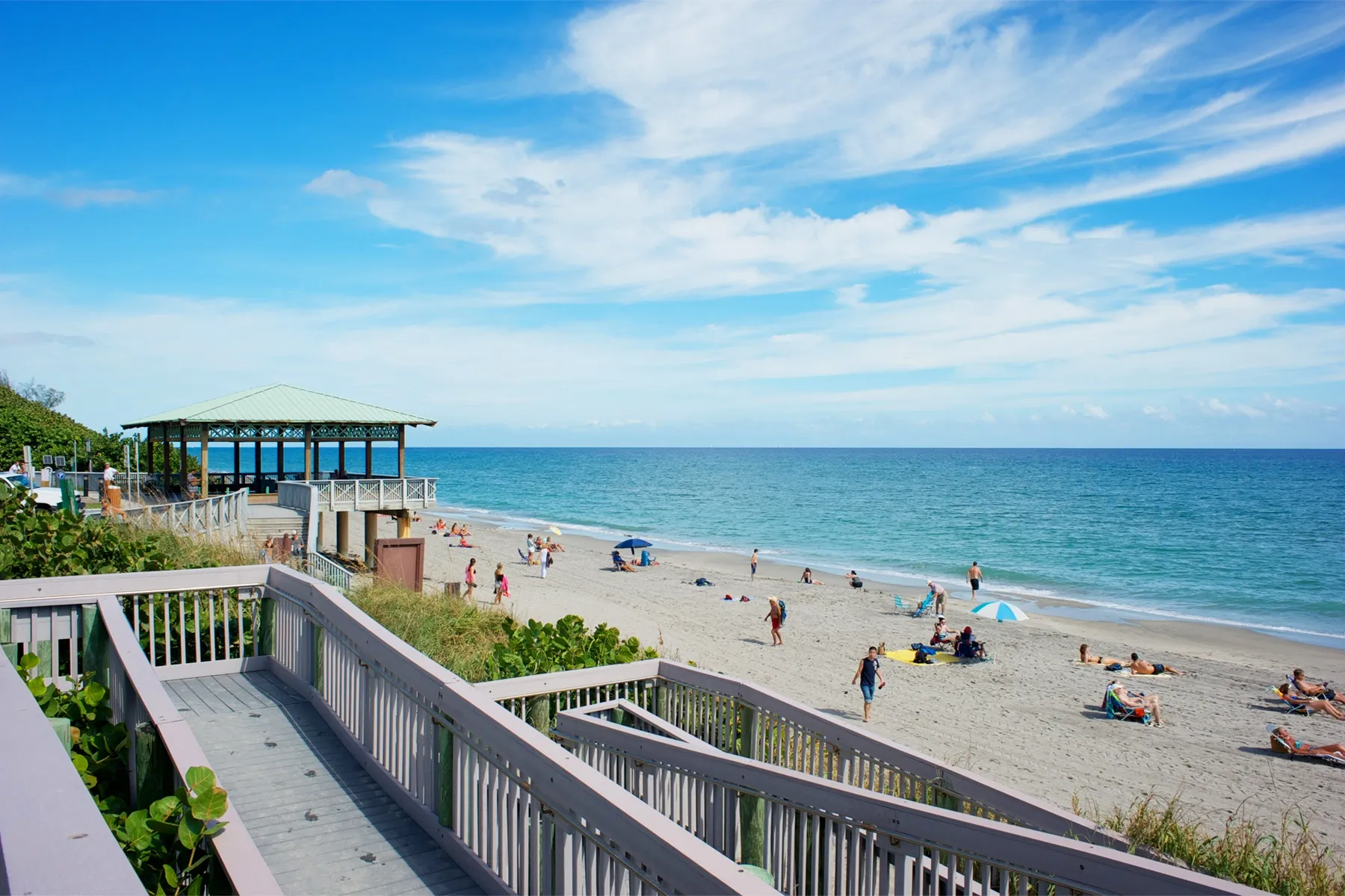Beautiful sunny day at a Coral Springs beach with people relaxing, highlighting coastal living and insurance needs.