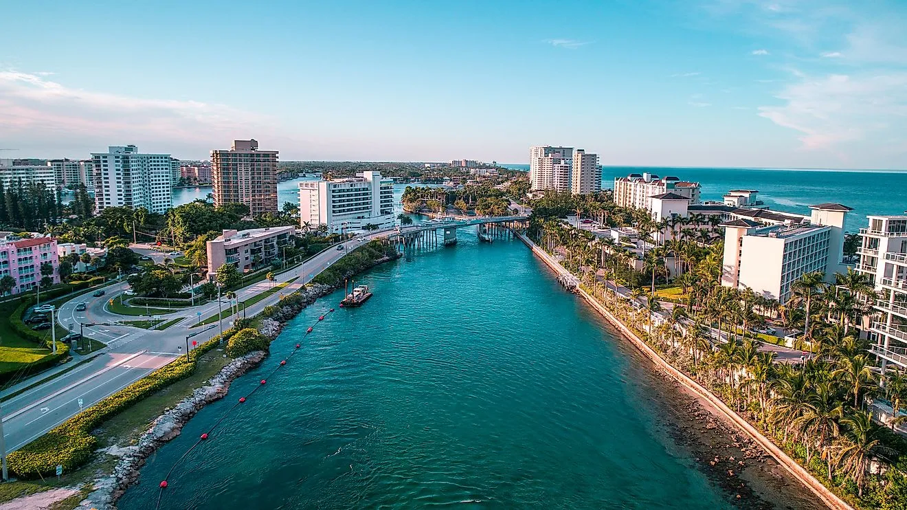 Aerial view of Boca Raton’s coastal cityscape with waterways, bridges, and palm-lined streets beside the Atlantic Ocean.