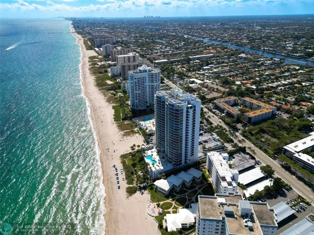 Aerial view of luxury beachfront condos and sandy coastline in Pompano Beach, Florida, ideal for homeowners.