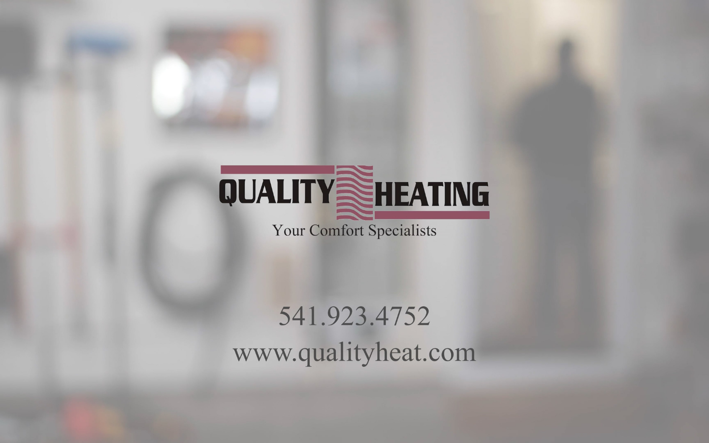Quality Heating logo with tagline Your Comfort Specialists, phone number 541.923.4752, and website www.qualityheat.com on blurred indoor background.