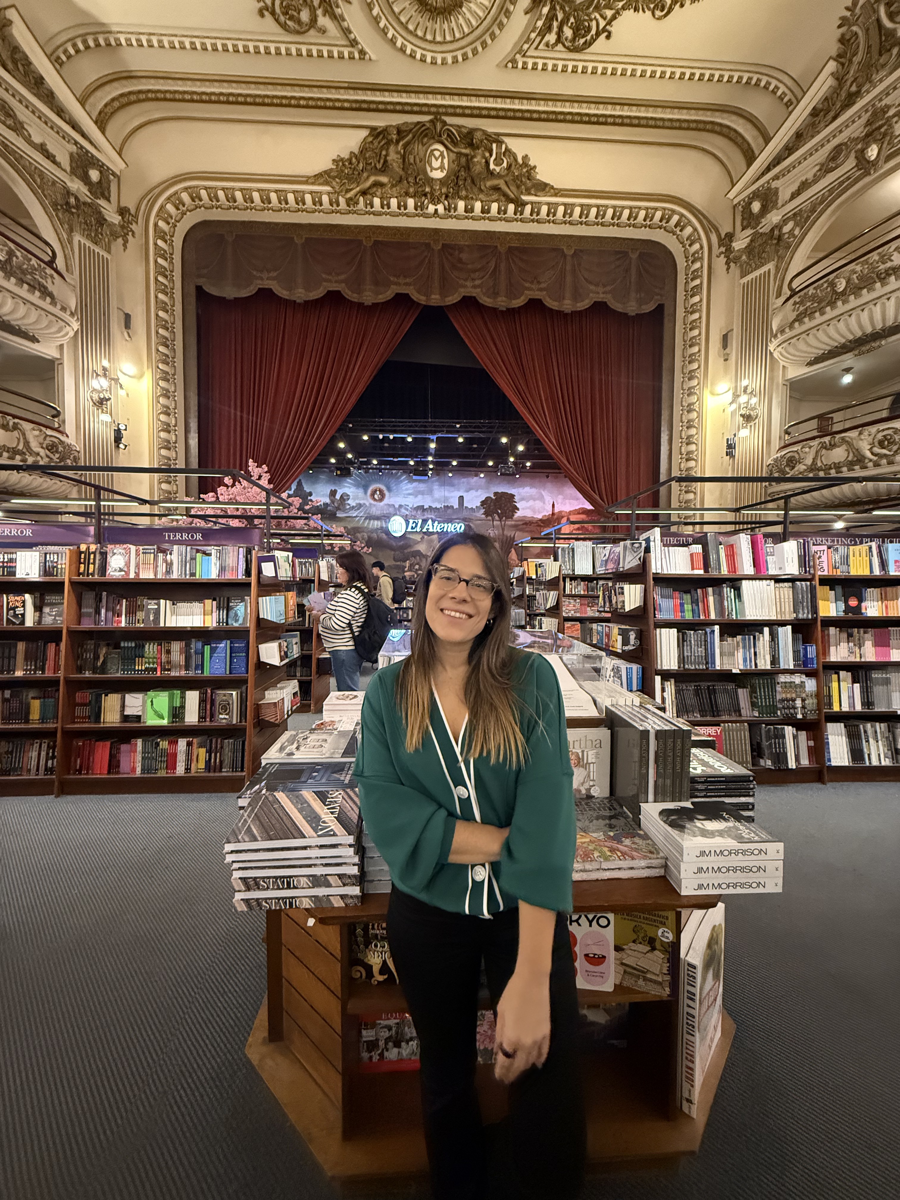 Marina Mammoliti sonriendo en la librería El Ateneo Grand Splendid, rodeada de libros