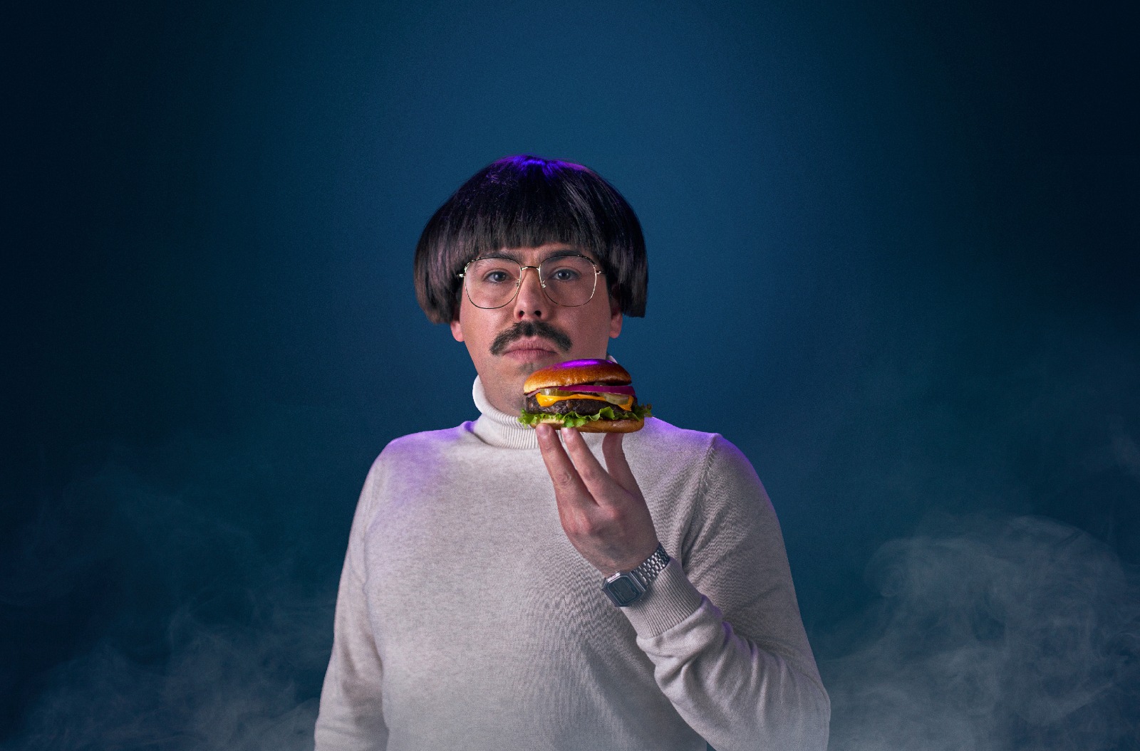 Fotografía publicitaría para marca de hamburguesas veganas con un hombre sosteniendo una hamburguesa
