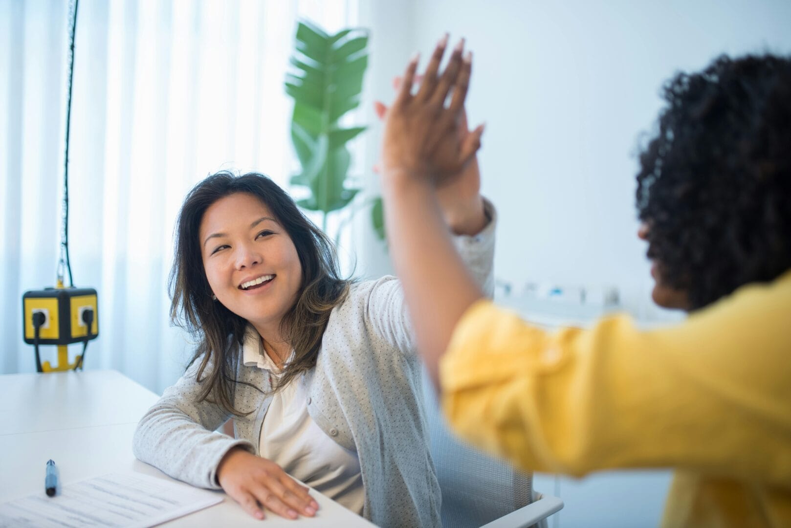 Two people high-fiving each other.