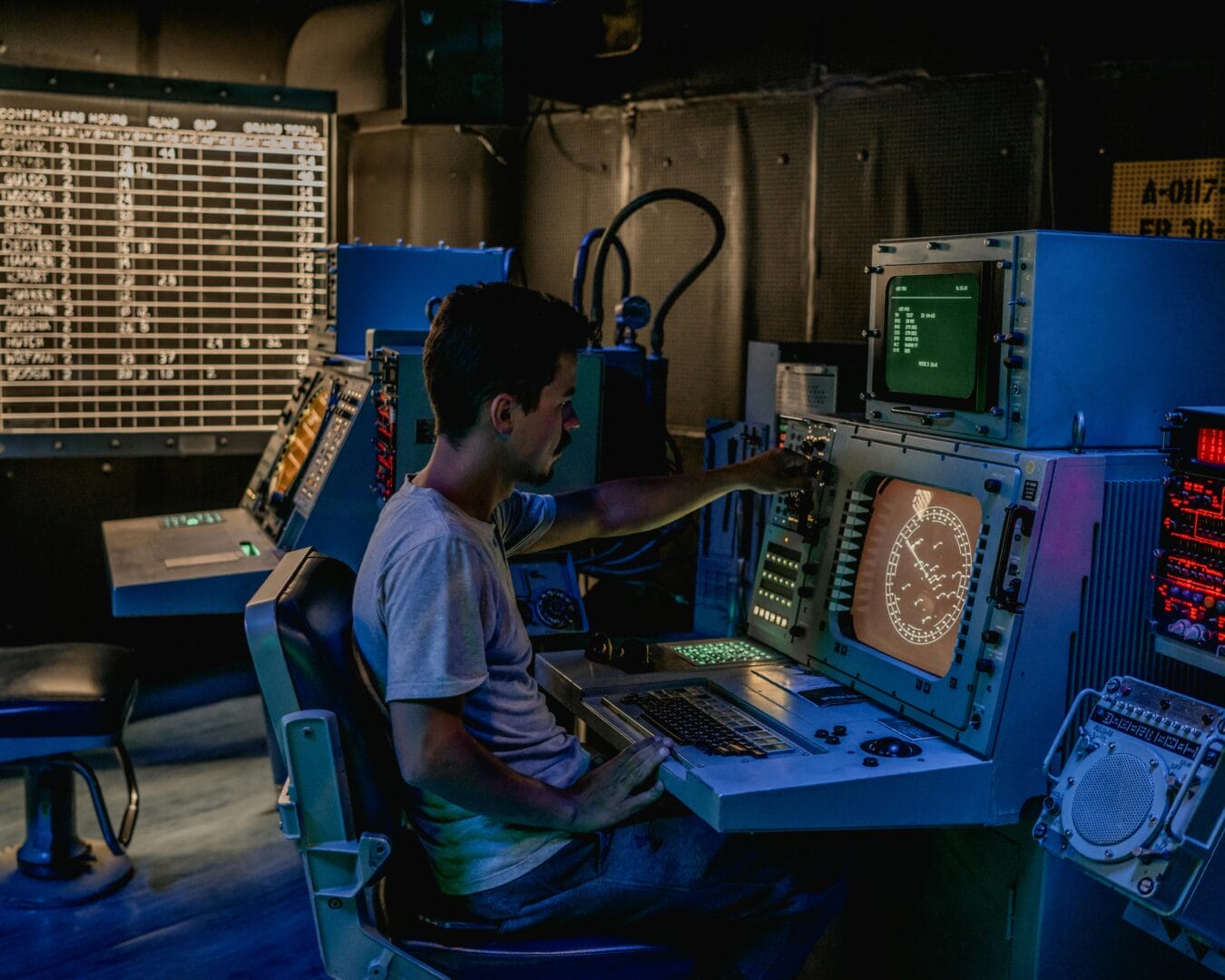 Person operating a control panel in a dark room.