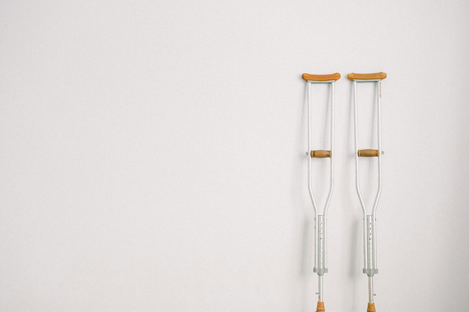 Pair of crutches leaning against a wall.