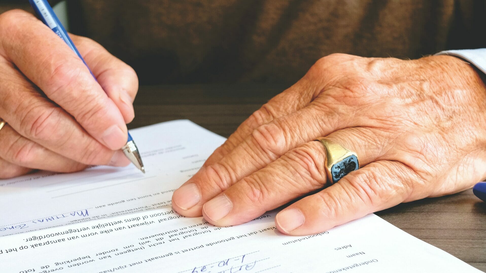 Close-up of hands signing a document with a pen