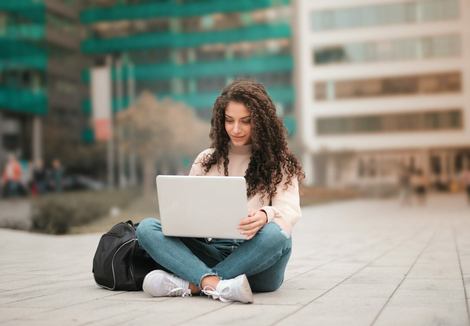 Woman sitting outdoors using a laptop