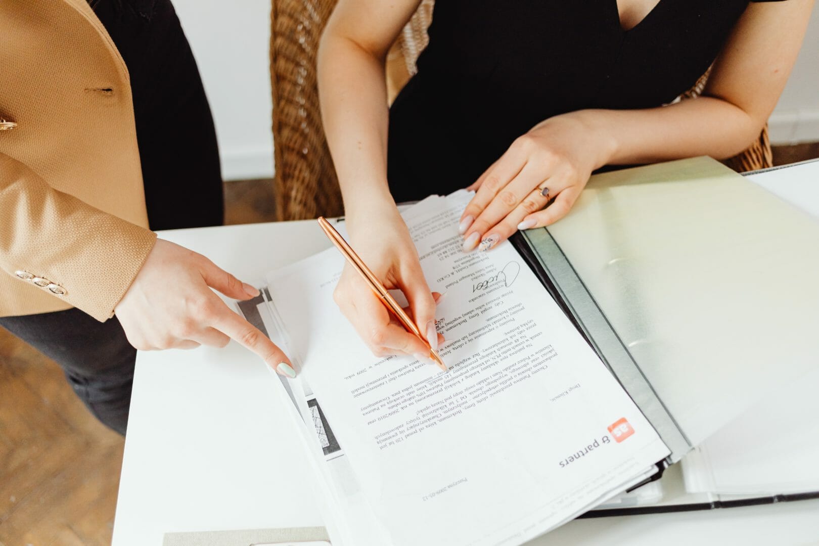 Two people reviewing and marking documents on a table