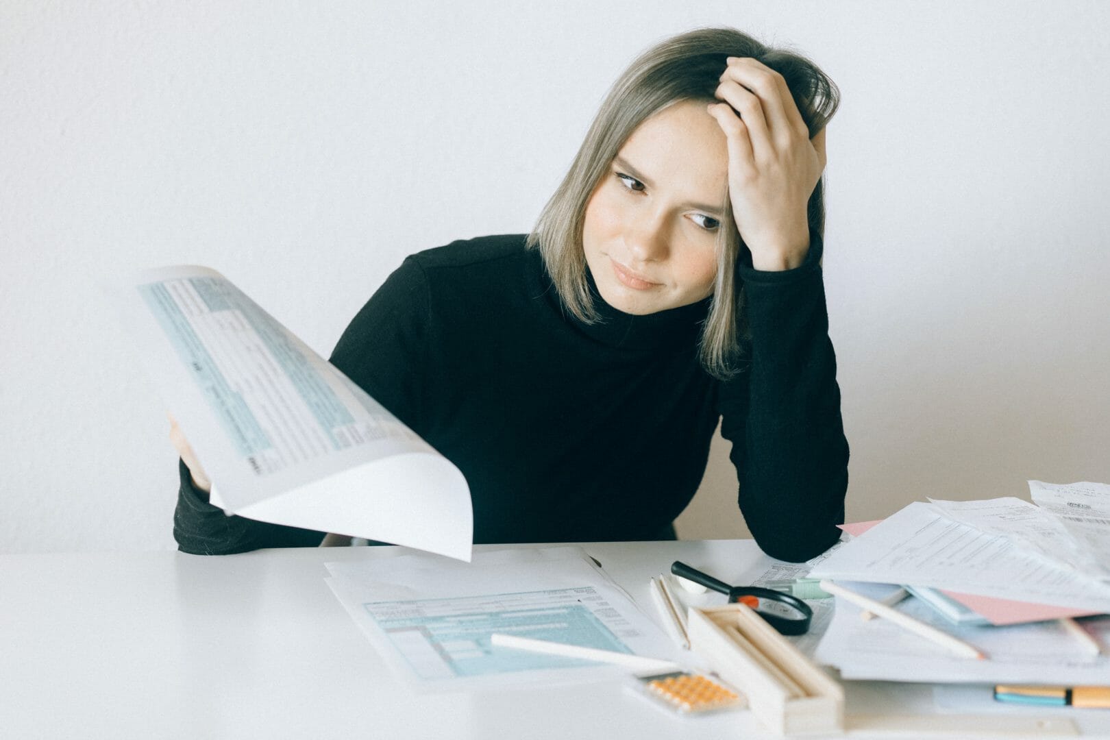Person sitting at a desk with documents and a calculator