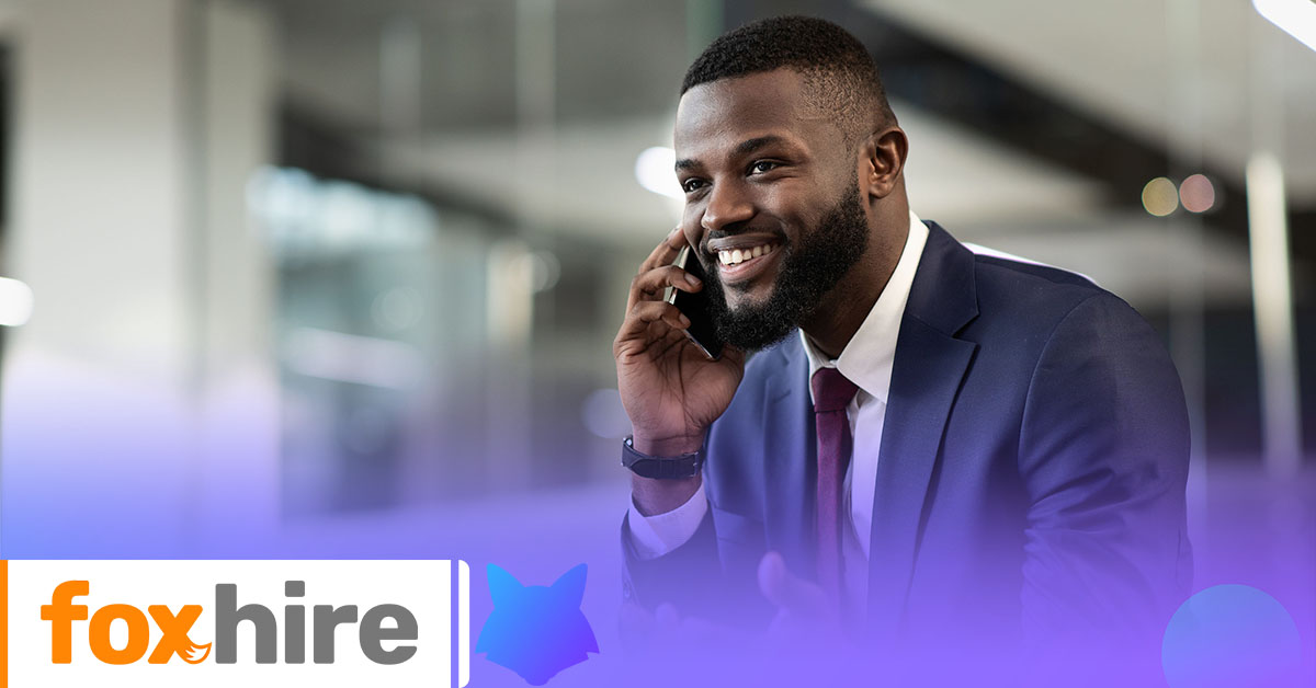 What Should be Included in an Employment Contract? | FoxHire|Woman smiling in an office with the foxhire logo