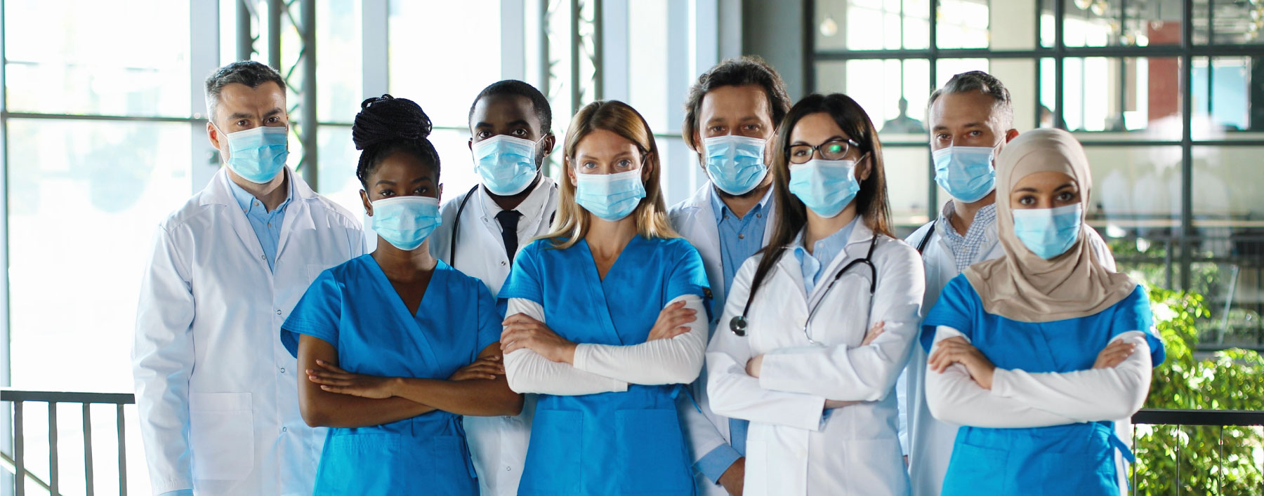 Diverse group of healthcare professionals wearing masks and standing together