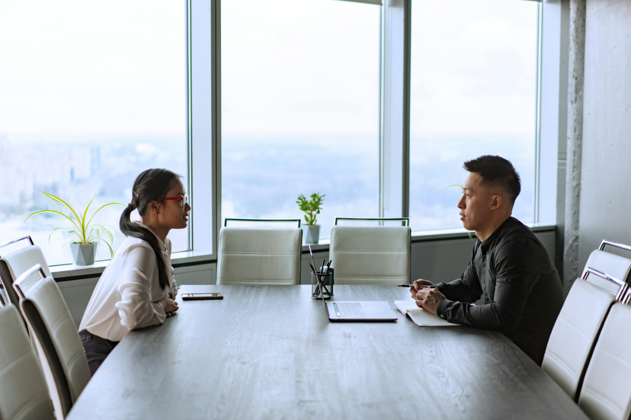 two professionals sitting across a table from each other while.