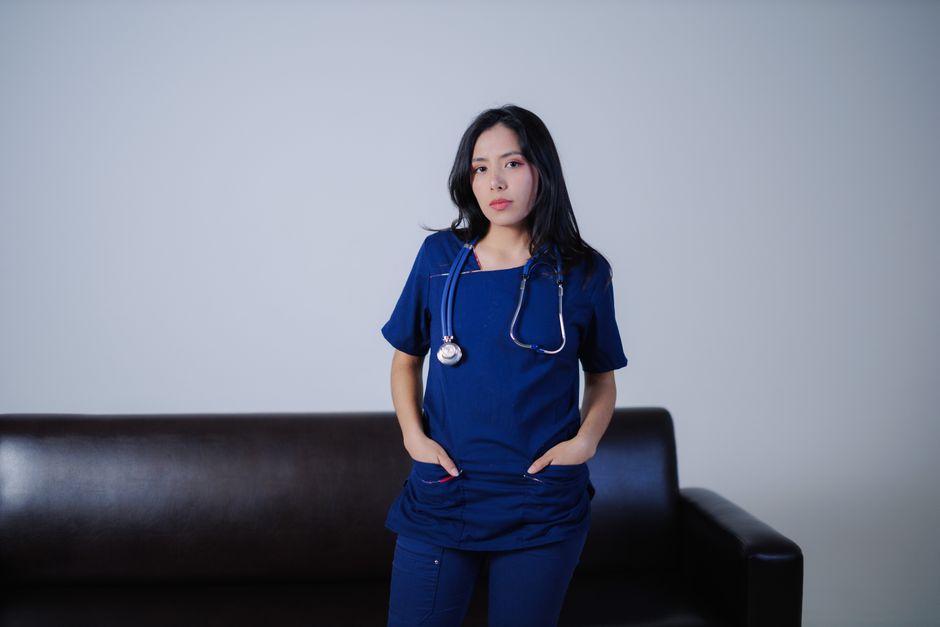 Registered nurse in navy scrubs with a stethoscope standing in a clinical setting