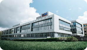 Bâtiment moderne de bureaux BDO avec façade en verre sous un ciel nuageux.