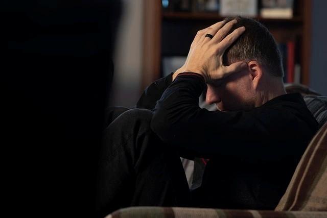 Un hombre sentado con una manoDescripción generada automáticamente con confianza media
