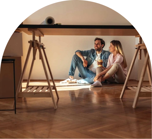 couple sitting on fresh hardwood floor renovations