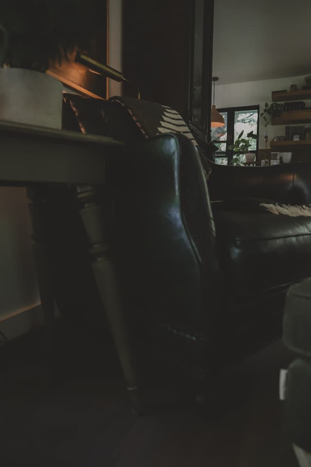 Home office with a black chair and moody lighting.
