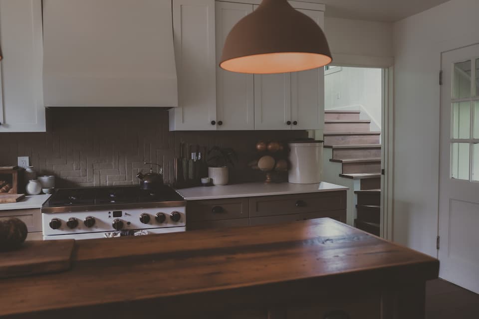 Warm kitchen with wood counters and hanging lights.
