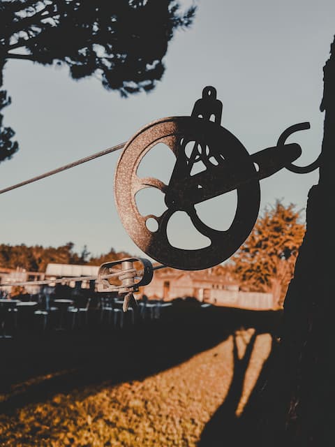  Vintage pulley wheel silhouetted against the sky.