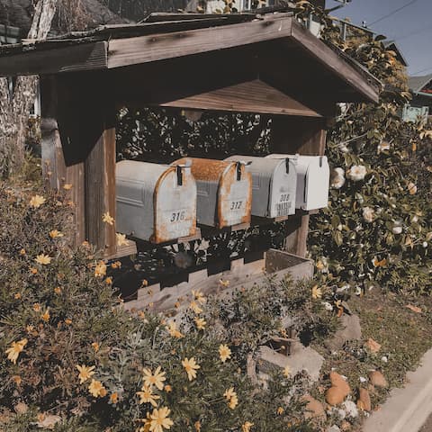 Cluster of rustic mailboxes in a garden setting.