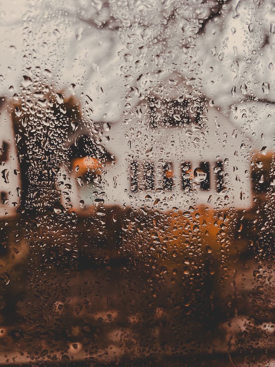 Foggy window with house reflection and water droplets.