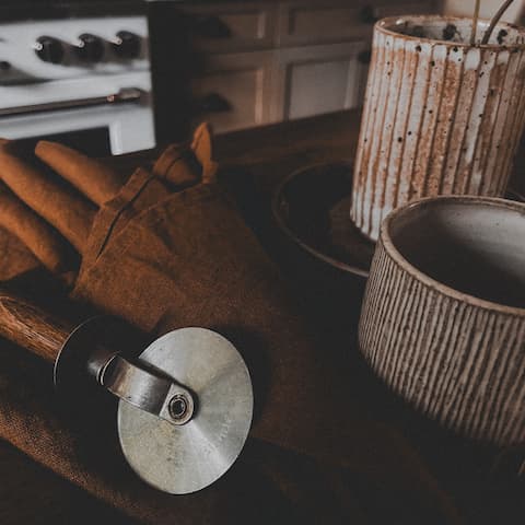 Rustic kitchen tools and bowls on a wooden surface.