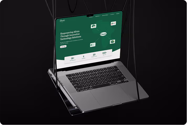 Silver laptop suspended by black cables against a black background displaying a green website homepage about empowering Africa with innovative technology solutions.