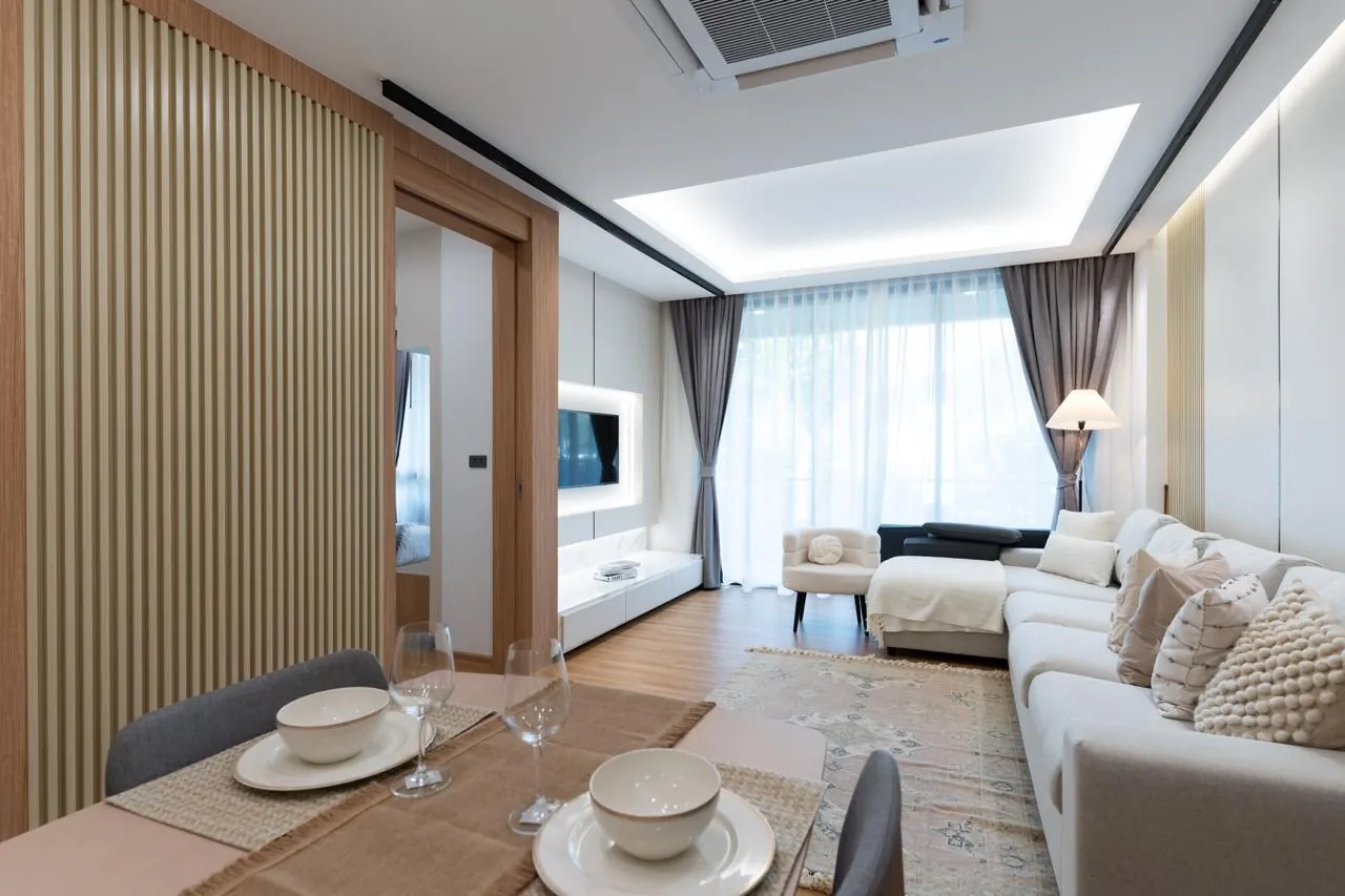 Апартаменты 2 спальни 90 м², ReLife Andaman — гостиная с угловым диваном и телевизором