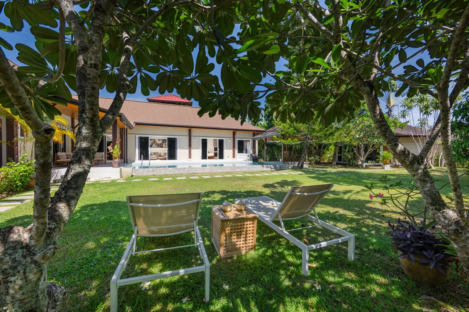 Villa Emilia, Най Харн — газон с шезлонгами под деревьями