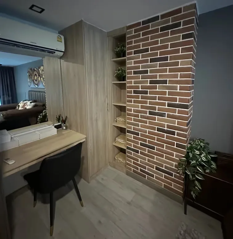 Desk by the shelving unit and brick wall — Utopia Nai Harn, Nai Harn