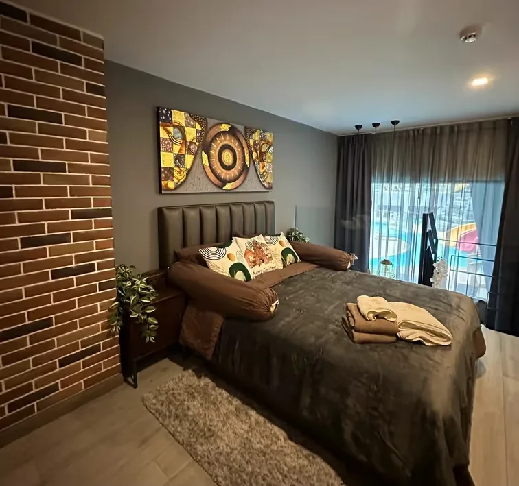 Bedroom with brick wall and artwork above the bed — Utopia Nai Harn, Nai Harn