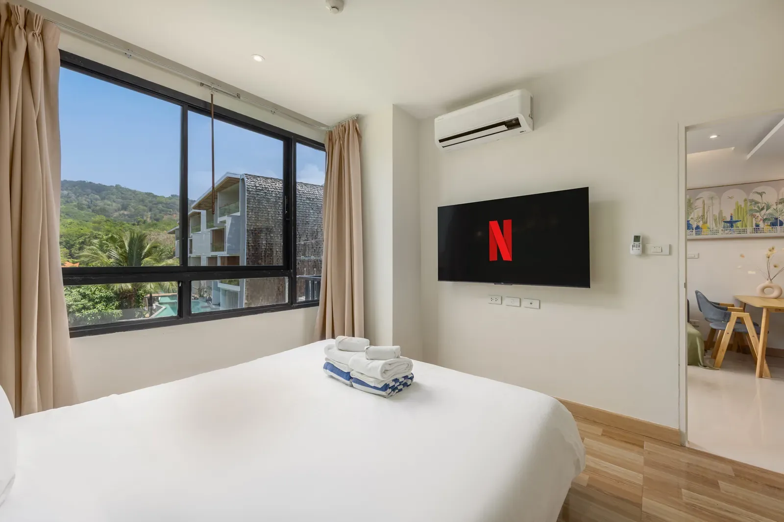 The Lago Suite Akko, Най Харн — спальня с телевизором и видом на зелень