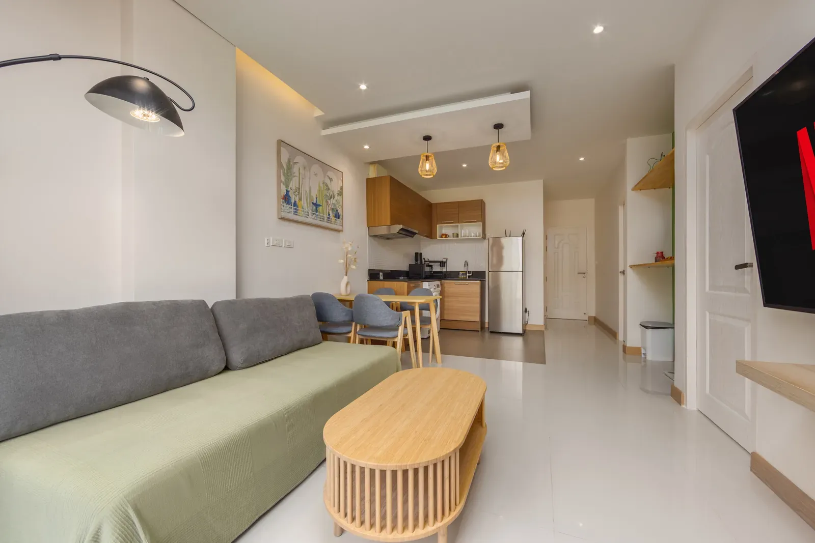 The Lago Suite Akko, Най Харн — гостиная с диваном, журнальным столом и кухней