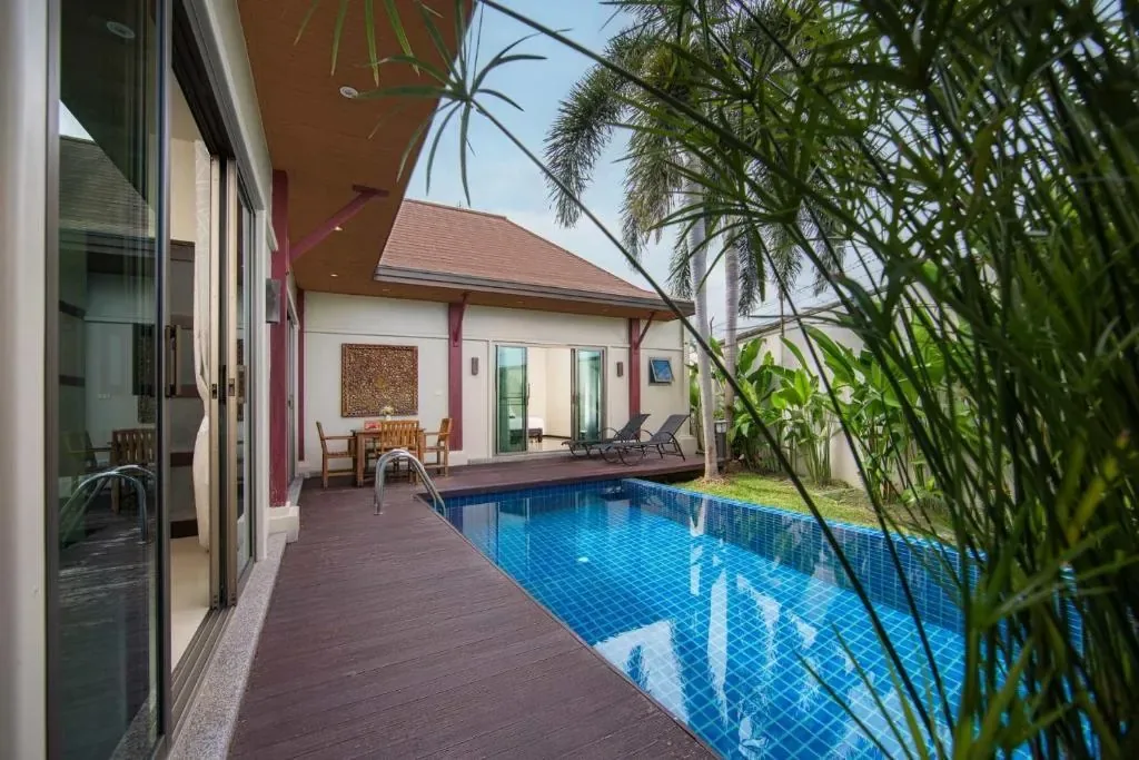 Villa Ikaroa, Най Харн — вид на бассейн из-за пальм