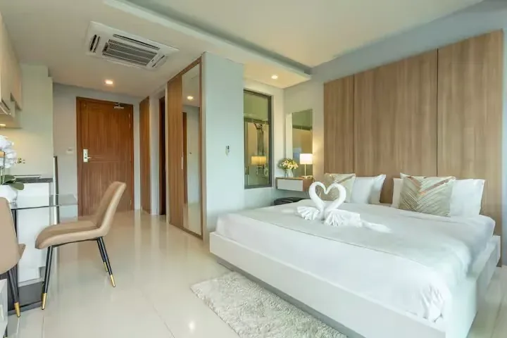 Swim-Up Condo, Най Харн — спальня с креслом и выходом на террасу