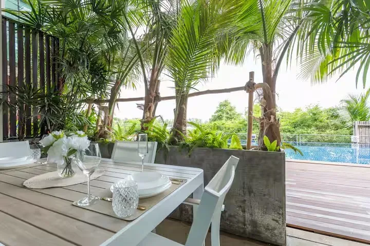 Swim-Up Condo, Най Харн — терраса с видом на бассейн и пальмы